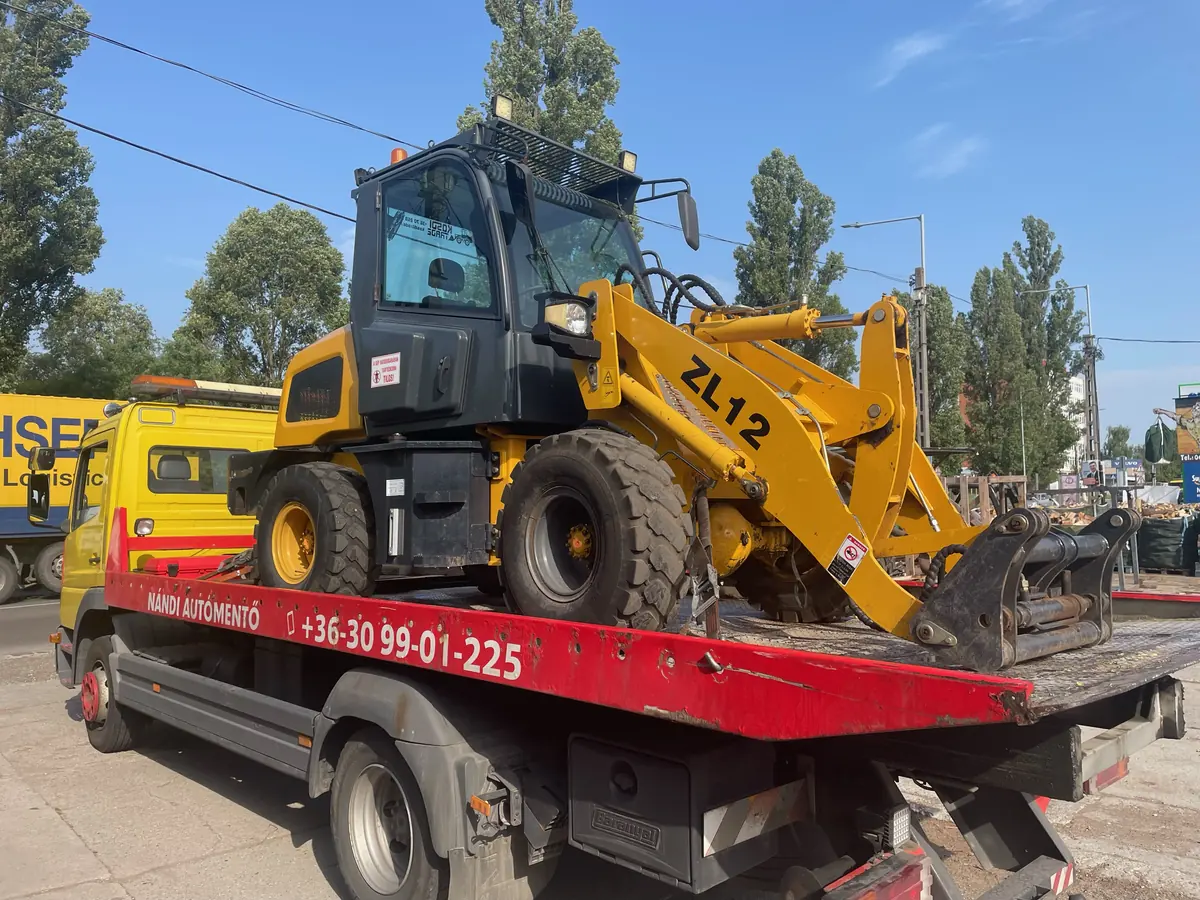 Homlokrakodó munkagép szállítása trélerrel