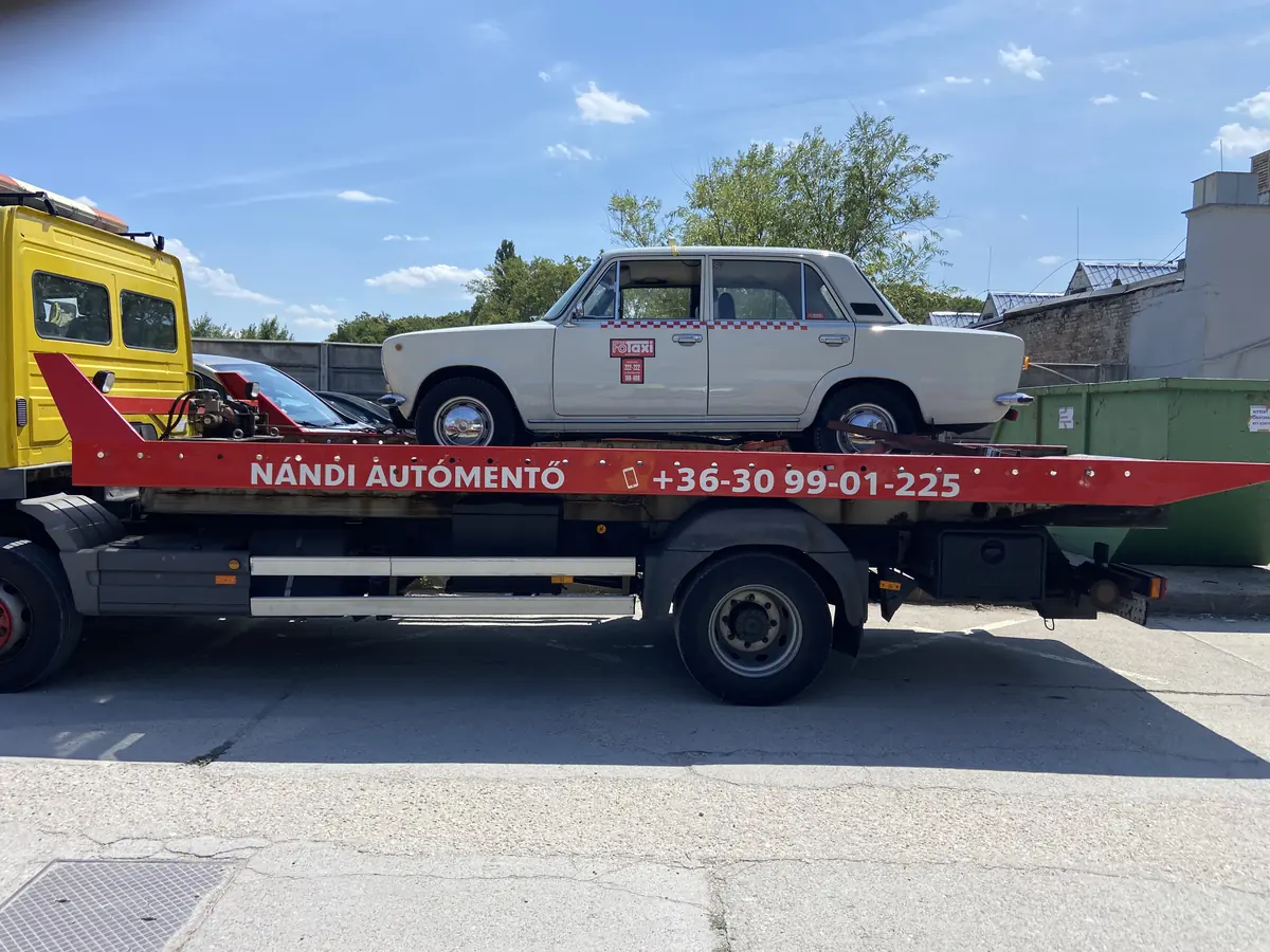 Fehér, kockás csíkos Főtaxi Lada Nándi trélerén