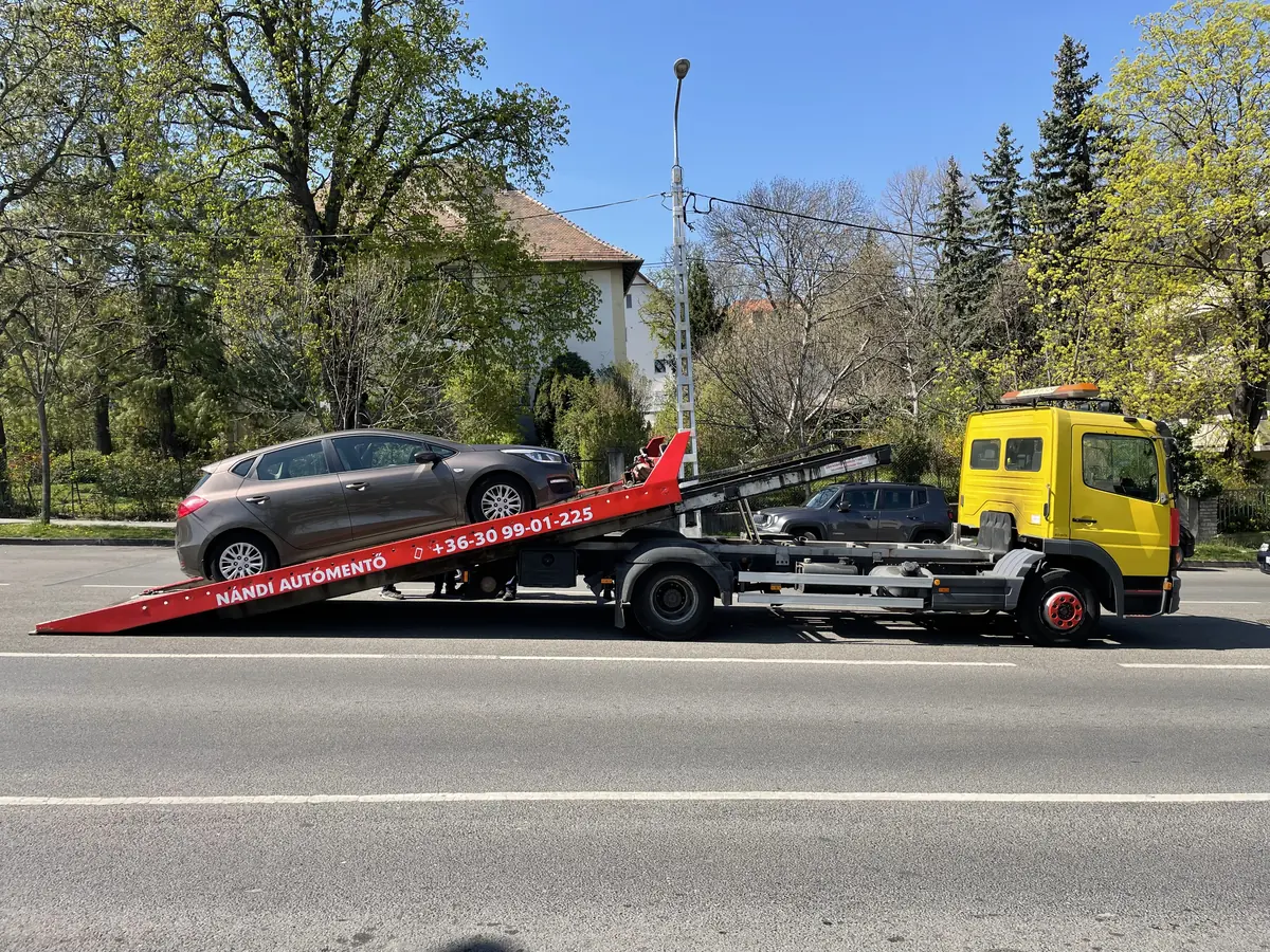 Személyautó felrakodása a trélerre egy budai utcán